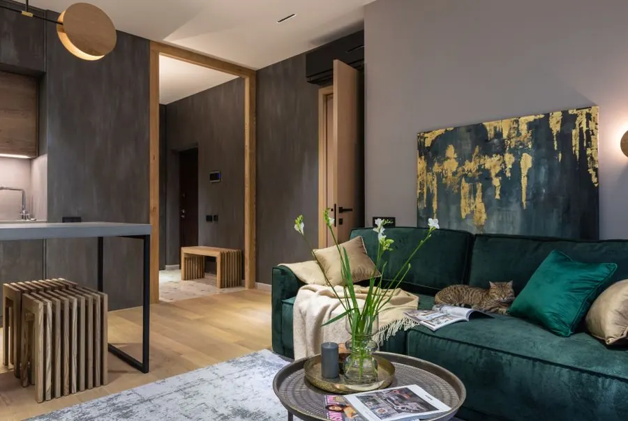 Earthy green interior paint palette with a green sofa and warm wood
