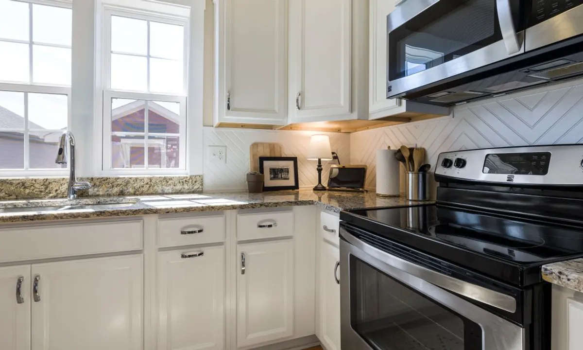 White kitchen cabinets showing the kind of finish homeowners compare when pricing cabinet painting