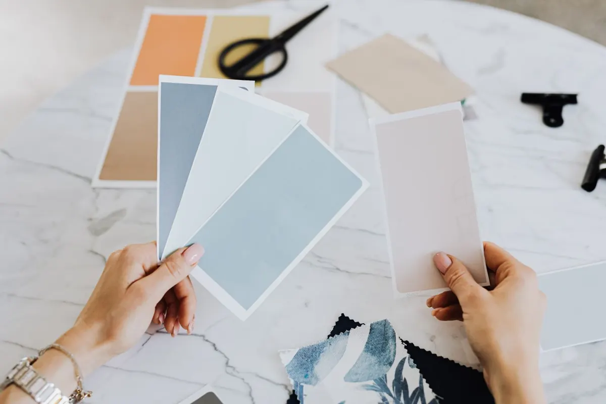 Hands holding paint color samples and materials for home color selection
