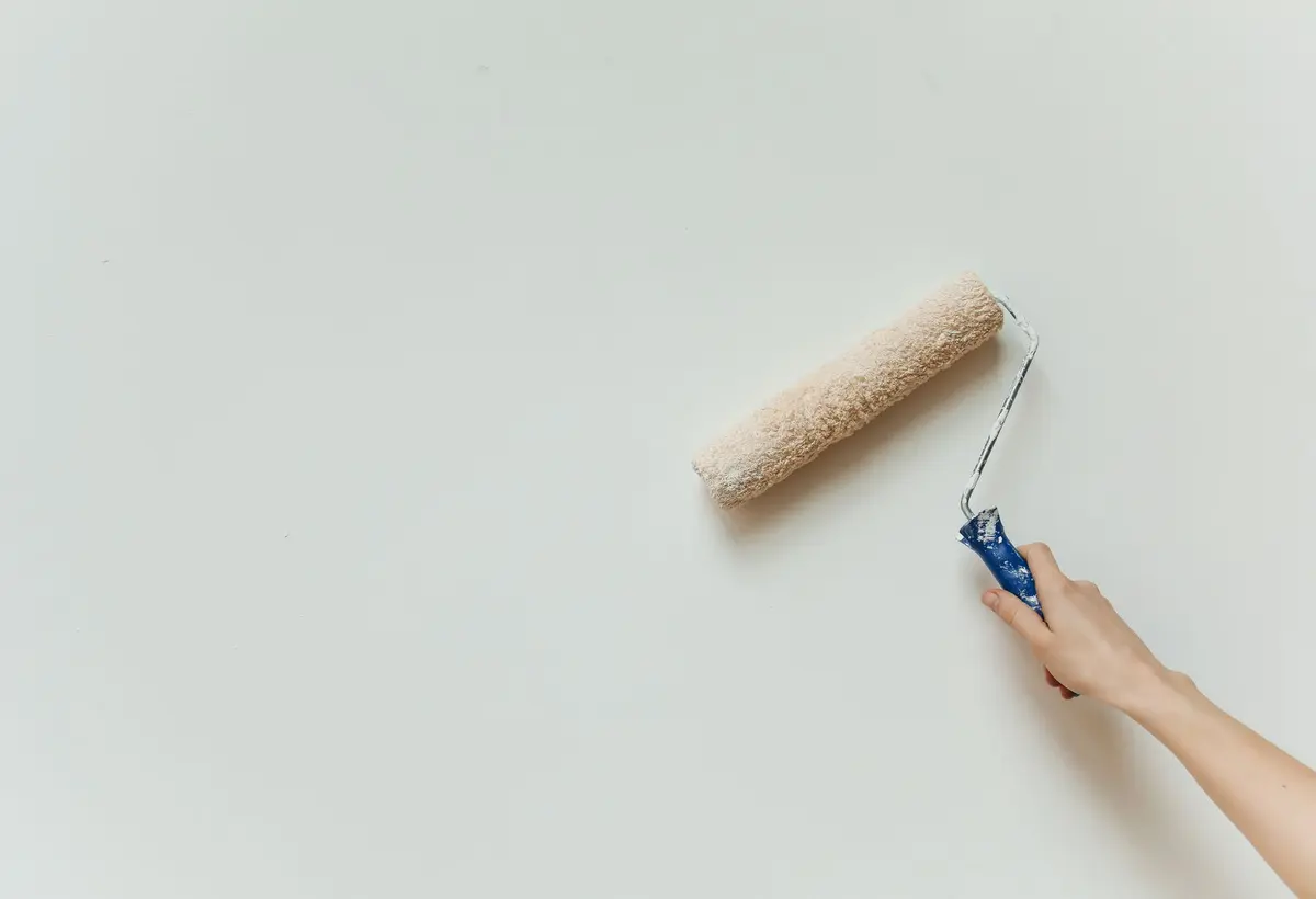 Painter applying a coat of paint to an interior wall