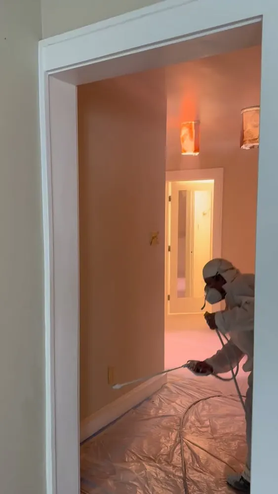 New Life Painting crew member spraying interior trim during a new construction painting project