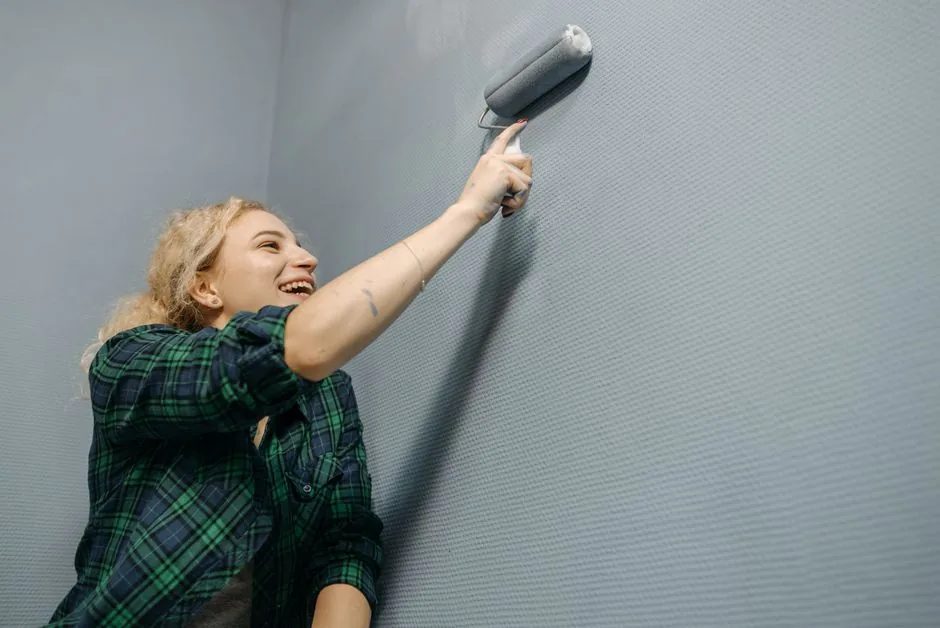 Austin homeowner comparing interior paint finishes while painting a wall