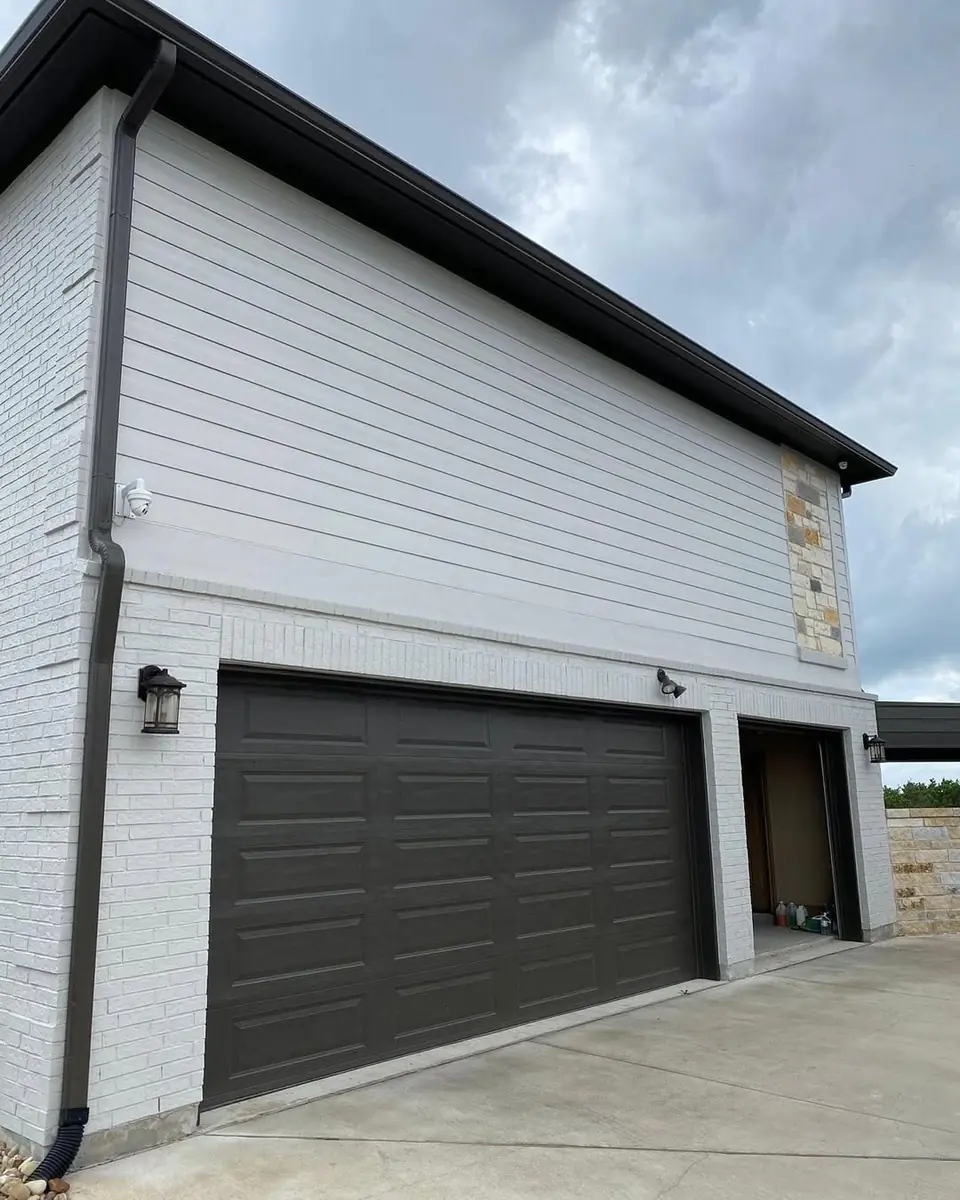 White brick exterior garage and black garage door painted by New Life Painting
