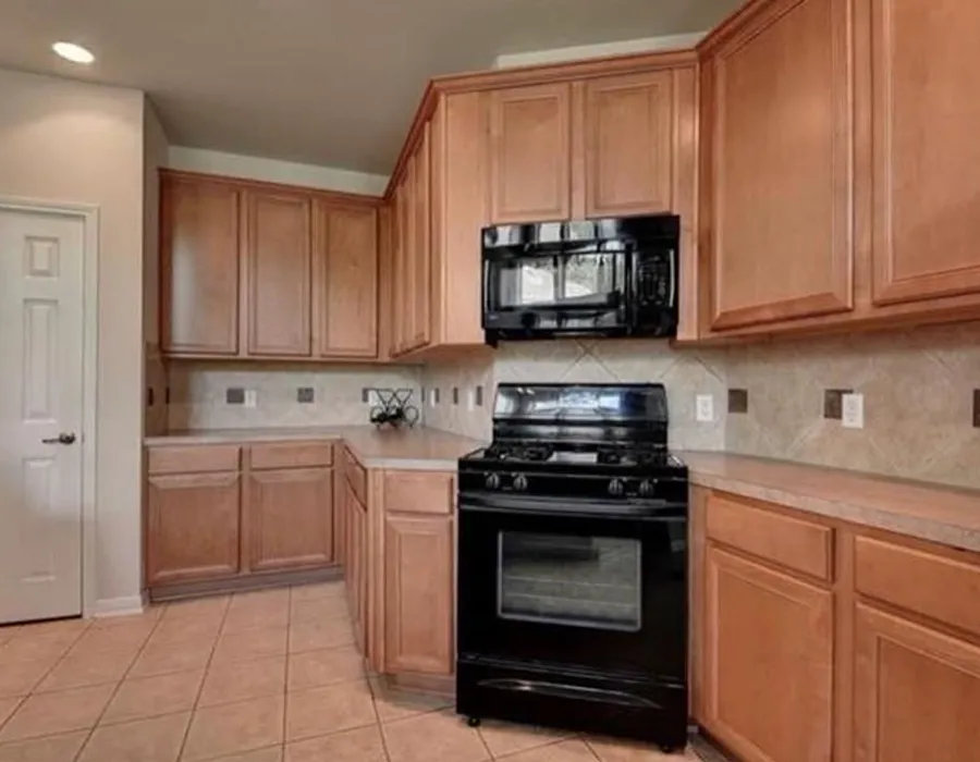 Wood kitchen cabinets before cabinet painting in an Austin home