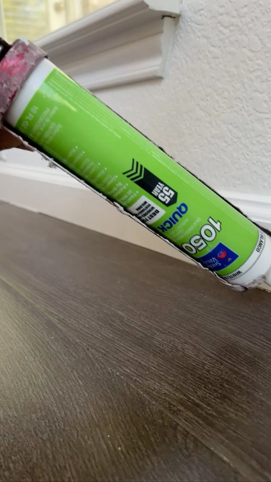 New Life Painting caulking an interior baseboard before painting in Austin